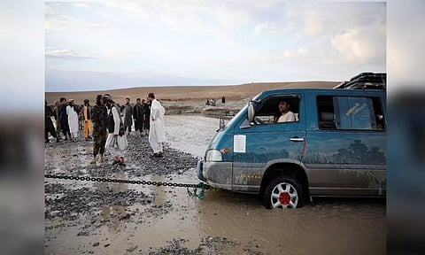 A mini van being towed out of flood water in Afghanistan (Reuters)