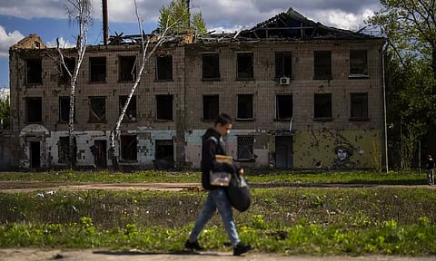 A young man walks past to partially attacked building in Russian attacks in Borodyanka (AP)