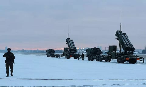 Serviceman patrols in front of the Patriot air defence system during Polish military training on the missile systems at the airport in Warsaw (Reuters)