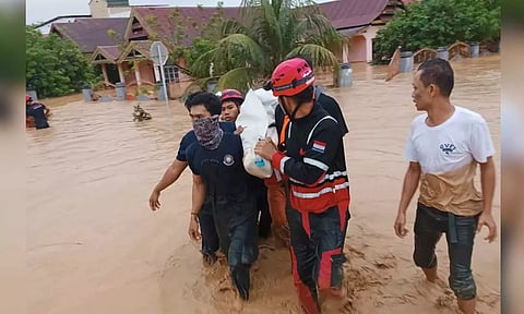 Rescuers carry a victim of a flood in Wajo, South Sulawesi, Indonesia (Reuters)