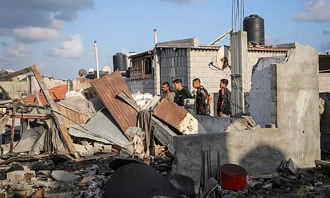  Palestinians inspect the site of an Israeli strike on a house (Reuters)