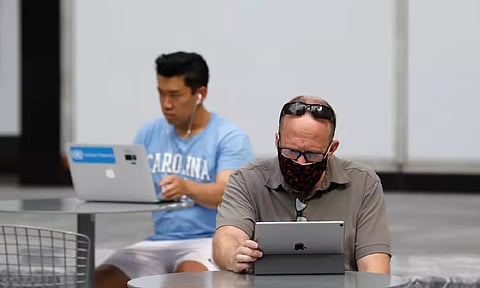 People use an Apple laptop computer and an Apple iPad in Manhattan (Reuters)