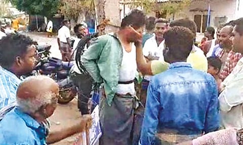 The chain-snatcher tied to the electric pole after being caught by public