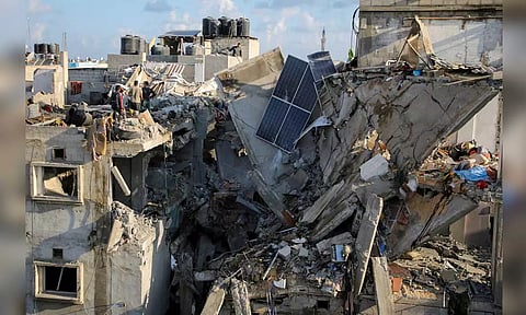 Palestinians inspect the site of an Israeli strike on a house, amid the ongoing conflict between Israel and the Palestinian Islamist group Hamas, in Rafah (Reuters) 