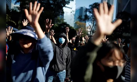 People raise their hands as they sing the protest anthem "Glory to Hong Kong" (Reuters) 