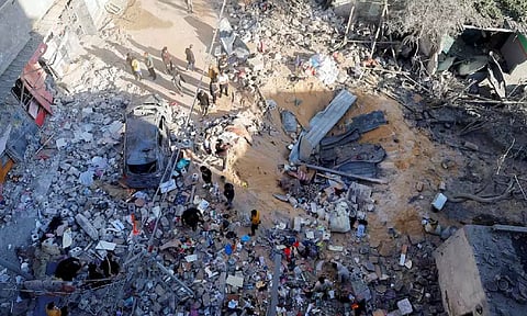 Palestinians inspect the site of an Israeli strike on a house in Rafah (Reuters)