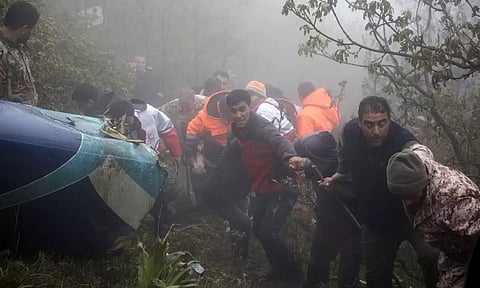 Rescue team members work at the scene of the helicopter crash (Image: AP)