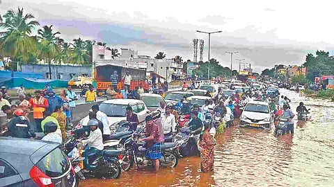 Motorist struggling to cross the inundated Salem-Madurai National Highway on Tuesday