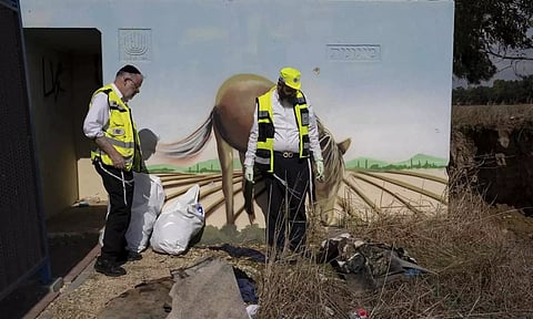 Volunteers from the ZAKA rescue service remove blood stains from a public bomb shelter on a road near the Israeli-Gaza border (Photo/AP)