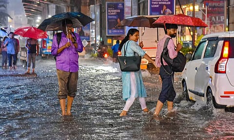 People wade through a water logged street in Kochi (PTI)