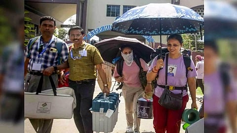 Polling officials carrying EVMs and other election material for their respective polling booths in East Medinipur. (Photo/ANI)