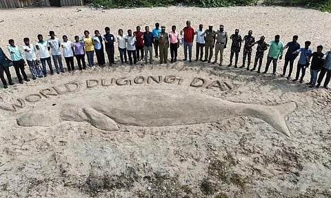 People taking awareness oath around the sand sculpture of dugong created by DFO Akhil Thampi in Thanjavur on Tuesday