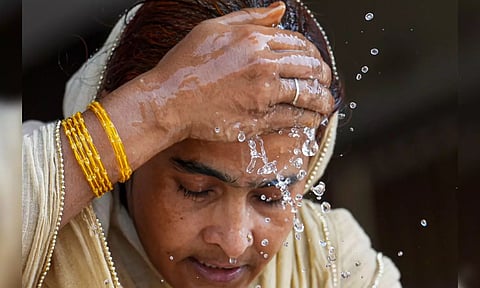 A woman splashes water on her face on a hot summer day amid heatwave (PTI)