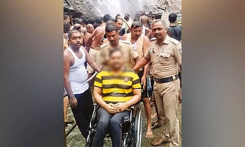 Cops of Tenkasi district with the differently-abled man, who enjoyed bathing at Courtallam falls