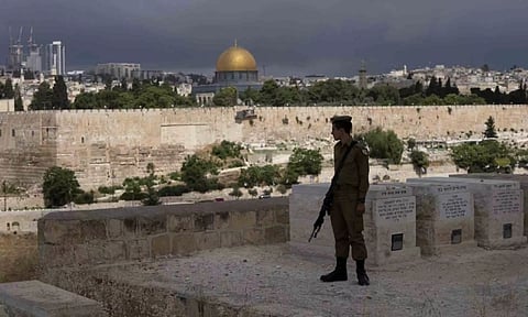 An Israeli soldier pauses in the Mount of Olives cemetery (Photo/AP)
