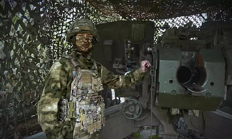 A Russian soldier poses for a photo next to a 2A65 "Msta-B" howitzer at a position in an undisclosed location in Ukraine. (AP)