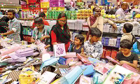 A crowded retail outlet with parents and kids shopping for school items (Mani Vasagan N)
