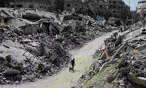 A Palestinian walks among the rubble of damaged buildings, which were destroyed during Israel's military offensive 