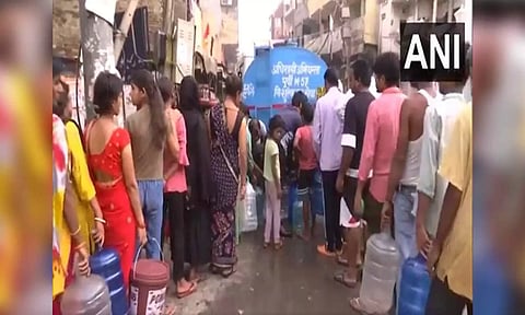 People collecting water from tankers in the Chilla Gaon of Mayur Vihar area (ANI)