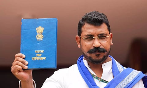MP from Nagina Chandrashekhar Azad holds a copy of the Constitution of India at the Parliament House complex (PTI)