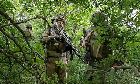 Russian soldiers walking through the forest area (AP)