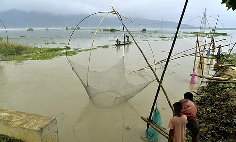 Villagers catch fish in flood water, in Morigaon district, Thursday