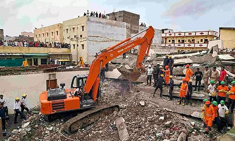  Surat officials and others during a rescue operation after a building collapse, in Surat (PTI)