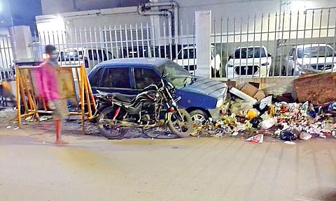 Garbage piles up around an abondoned car near Sir Theagaraya College Metro Station