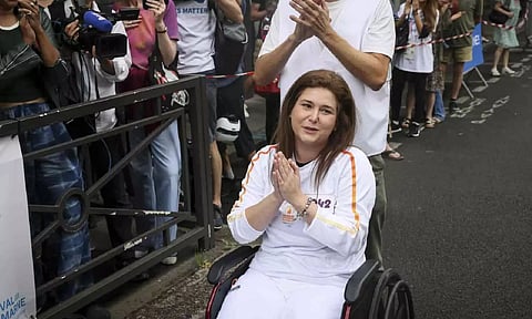 Press agency photographer Christina Assi arrives for the Olympic torch relay at the 2024 Summer Olympics (AP)