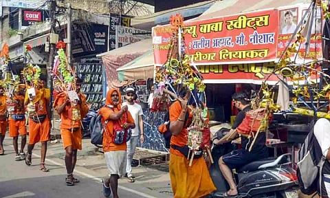 Kanwariyas walk past a shop on which banners with shopkeeper's name was put up on Kanwar Marg (PTI)
Read more at: https://www.onmanorama.com/news/india/2024/07/22/sc-imposes-stay-on-order-asking-eateries-to-display-name-of-owners.html