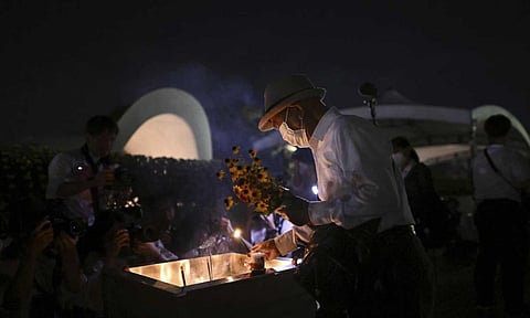 A man places incense in front of the cenotaph dedicated to the victims of the atomic bombing (AP)