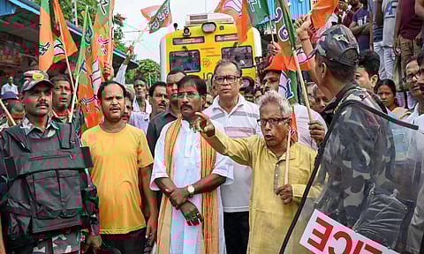 BJP MP Jagannath Sarkar along with party workers block railway tracks at Shantipur station as security personnel stand guard during the party's 12-hour general strike in Bengal (PTI)
