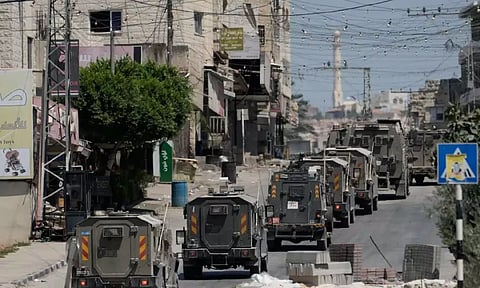 A column of Israeli Army armored vehicles leave following a military operation in the West Bank town