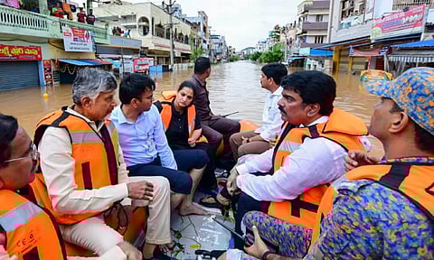 Andhra Pradesh Chief Minister N Chandrababu Naidu with others during a visit to a flood-affected area, in Vijayawada (PTI)
