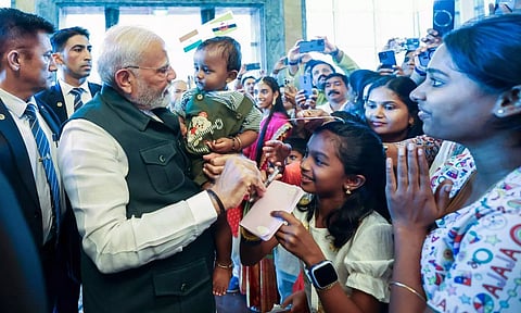 Prime Minister Narendra Modi being welcomed by members of the Indian community upon his arrival at a hotel (PTI)