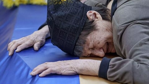 A mother cries near the coffin of her killed son in a Russian rocket (AP)