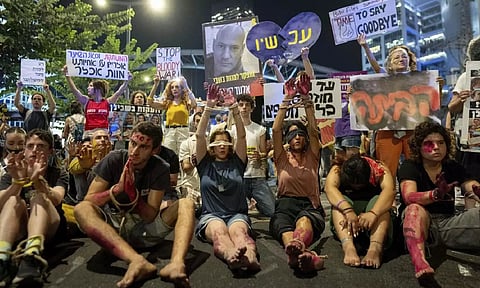 Blindfolded and bounded protesters take part in a protest against Israeli Prime Minister Benjamin Netanyahu