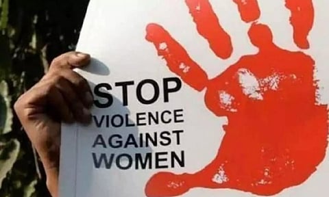 A placard denouncing violence against women being held at a protest march (PTI)