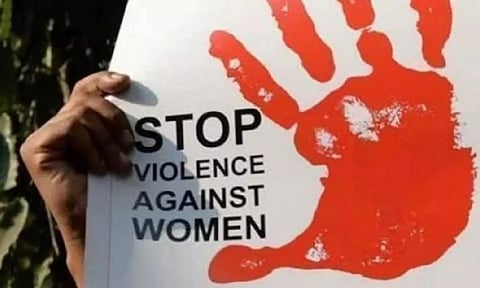 A placard denouncing violence against women being held at a protest march (PTI)