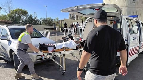 Civil defence carry a wounded man (AP)