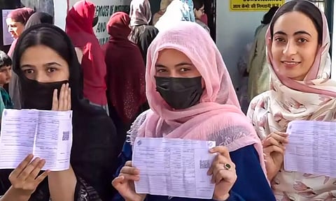 Women voters show their voting slips at a women-only polling station during the first phase of Jammu and Kashmir Assembly elections, in Kishtwar district (PTI)
