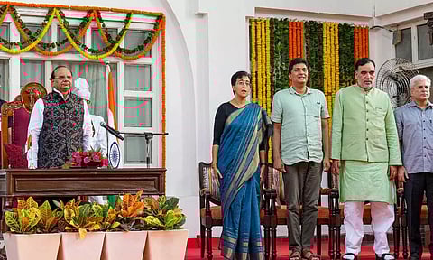 Delhi Lt. Governor V.K. Saxena with CM-designate Atishi, and AAP leaders during her swearing-in ceremony, at Raj Bhavan, in New Delhi (PTI)