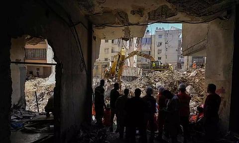 Emergency workers use excavators to clear the rubble at the site of Friday’s Israeli strike in Beirut’s southern suburbs, Lebanon (AP)