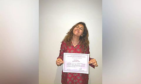 Keneeshaa Francis with her certificate from Lama Fera Practical Research Centre