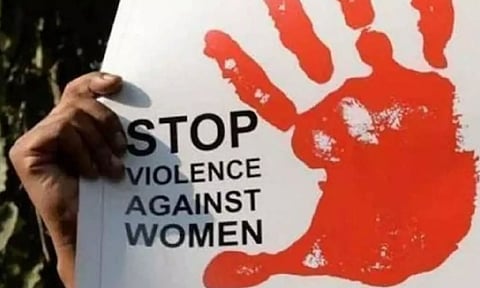 A placard denouncing violence against women being held at a protest march (PTI)
