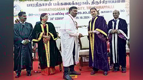 PhD scholar Israel Inbaraj handing over a petition to Governor Ravi during the Bharthidasan University convocation ceremony 
