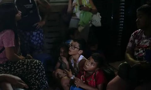Venezuelan migrant Daniel Dura, waits next to his mother Rannely Duran inside a house before crossing the Suchiate River (AP)