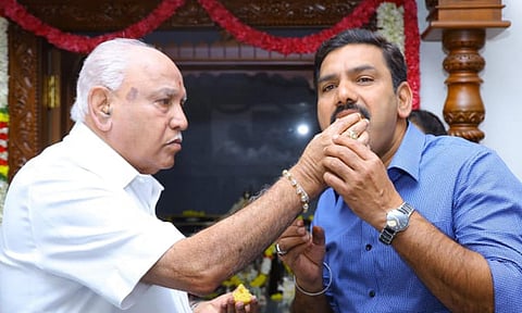 Karnataka BJP President B Y Vijayendra being offered sweets by his father B S Yeddyurappa on his birthday at their residence in Bengaluru (PTI) 