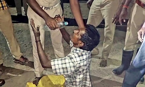 A police officer offers water to the man after bringing him down 