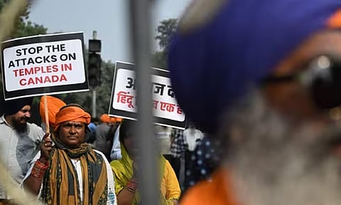A Nihang Sikh warrior holds a placard as he takes part in a protest near the Canadian embassy in New Delhi against the recent attack on a Hindu temple in the city of Brampton (AFP) 